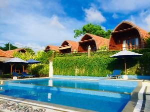 a villa with a swimming pool and a house at Druwa Bali in Uluwatu