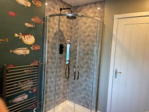 a shower with a glass door in a bathroom at The Inn @ Y-Not in Thurso