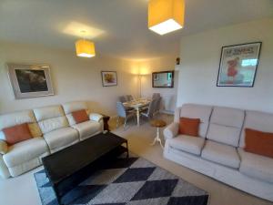 a living room with two white couches and a table at Whole house, easy walk to town centre, Parking, Self Catering, Great View, 3 bedrooms, sleeps 6 in Stratford-upon-Avon