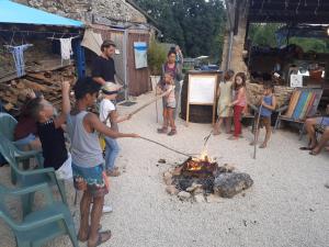 a group of children standing around a fire at restyled bohemian mobil home la vie en rose in Montcléra