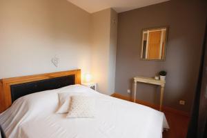 Appartement Bruat في كولمار: غرفة نوم بسرير وملاءات بيضاء ونافذة