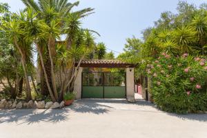 a garage with a green door and palm trees at Garden of Eden in Kalamaki