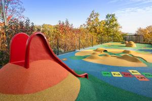 einen Spielplatz mit Rutsche in einem Park in der Unterkunft Hotel Golf Depandance in Prag