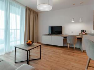 a living room with a couch and a table at VacationClub – Jantaris Apartament B34 in Mielno