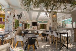 a restaurant with tables and chairs in a room at Garden of Eden in Kalamaki