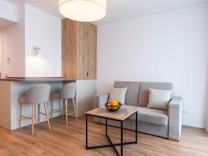 a living room with a couch and a table at VacationClub – Jantaris Apartament B35 in Mielno
