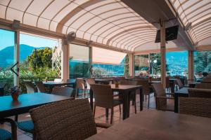 un restaurante con mesas, sillas y ventanas grandes en Happy Camp mobile homes in Villaggio Turistico Internazionale Eden, en San Felice del Benaco