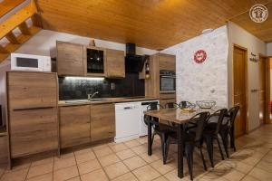a kitchen with a table and chairs in a room at La Tomba Val-Cenis Lanslevillard in Lanslevillard