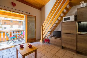 a living room with a kitchen and a balcony at La Tomba Val-Cenis Lanslevillard in Lanslevillard
