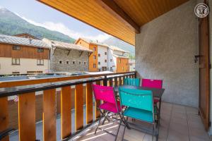 a balcony with chairs and a table on a balcony at La Tomba Val-Cenis Lanslevillard in Lanslevillard