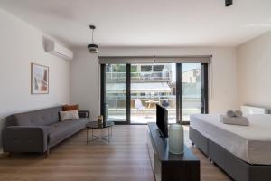 雅典Leochares Lifestyle Apartments - Self check-in的一间带床、沙发和电视的卧室