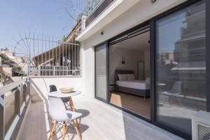 雅典Leochares Lifestyle Apartments - Self check-in的一个带桌椅的阳台和一间卧室