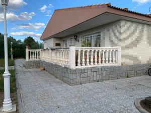 ein Haus mit einer Steinmauer und einem weißen Zaun in der Unterkunft Maroteras in Maroteras