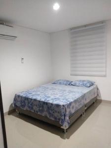um quarto com uma cama num quarto branco em Casa Condominio Diomedes Daza Valledupar em Valledupar
