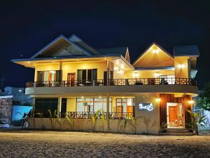 a large house with a balcony at night at Beach Stone in Gulhi