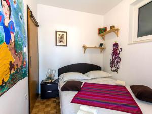 ein Schlafzimmer mit einem Bett mit einem bunten Teppich darauf in der Unterkunft Apartment Bilic in Zadar
