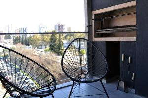 a pair of chairs sitting on a balcony with a window at Loi Flats Neuquen, Edificio Tucumán in Neuquén