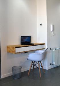 a desk with a laptop on a wall with a chair at Loi Flats Edificio Tucuman in Neuquén
