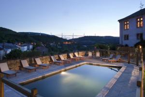 a patio area with chairs, tables, and a pool at Chateau de Creissels in Creissels