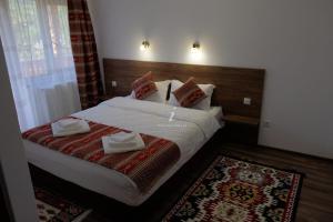 a hotel room with a bed with towels on it at PENSIUNEA PLAI STRABUN in Strîmtura