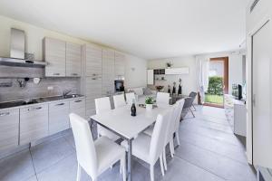 a kitchen and dining room with a white table and chairs at La Romantica Holiday Homes by Wonderful Italy in Manerba del Garda