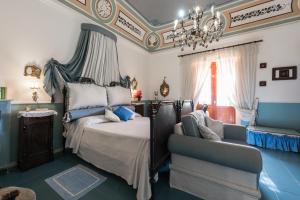 a bedroom with a bed and a chandelier and a chair at Villa Mariella Pittorino - camere in B&B in Leni