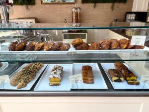 a display case with different types of donuts and pastries at Hotel Franca in Milano Marittima