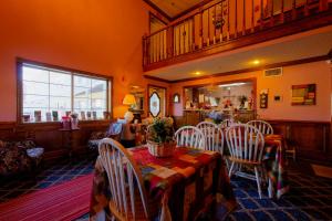 a dining room with a table and white chairs at Hotel O Eureka Springs - Christ of Ozark Area in Eureka Springs