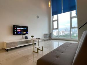 a living room with a couch and a flat screen tv at The Scott Garden Kuala Lumpur by BeeStay Management in Kuala Lumpur