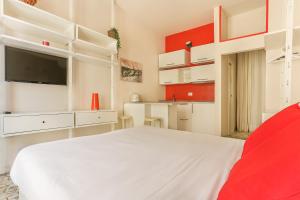 um quarto com uma cama branca e uma televisão de ecrã plano em The Red Loft in Ponte Vecchio em Florença