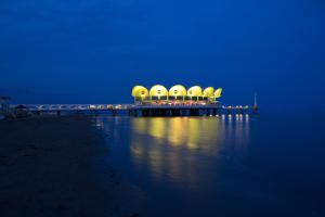 a building on a pier over the water at night at Zero5.Zero5 in Lignano Sabbiadoro