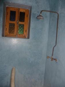 a shower with a light on a blue wall at Riad Jade Mogador in Essaouira