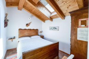 a bedroom with a bed in a room with wooden ceilings at Cà mea Dina Apartments in Ledro
