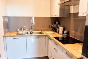 eine Küche mit weißen Schränken und einem Waschbecken in der Unterkunft Bright Modern Arthurs Seat 2 Bedroom Apartment in Edinburgh