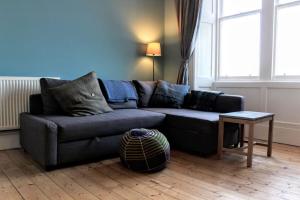 a living room with a couch and a table at Bright Modern Arthurs Seat 2 Bedroom Apartment in Edinburgh