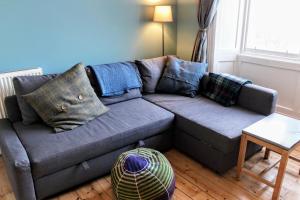 ein graues Sofa im Wohnzimmer mit einem Tisch in der Unterkunft Bright Modern Arthurs Seat 2 Bedroom Apartment in Edinburgh