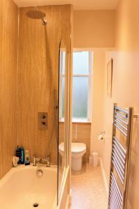 ein Bad mit einer Badewanne und einem WC in der Unterkunft Bright Modern Arthurs Seat 2 Bedroom Apartment in Edinburgh
