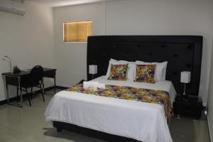 a bedroom with a large bed and a desk at Hotel Cafeira in Pereira