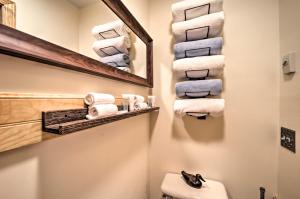 Baño con una pila de toallas y espejo en Cozy Mtn Getaway - Steps to Beech Mountain Resort!, en Beech Mountain