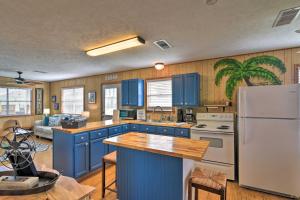 a kitchen with blue cabinets and a white refrigerator at Colorful Crystal Beach Home with Ocean View! in Crystal Beach