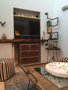 a living room with a flat screen tv on a entertainment center at Spacious 1 Bedroom Split Level Old Pub Conversion Tower Bridge in London