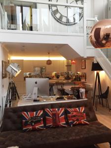 a living room with a large clock and a couch at Spacious 1 Bedroom Split Level Old Pub Conversion Tower Bridge in London