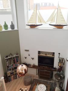 a living room with a tv and sailboats on a window at Spacious 1 Bedroom Split Level Old Pub Conversion Tower Bridge in London