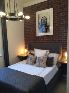 a bedroom with a bed with a brick wall at Spacious 1 Bedroom Split Level Old Pub Conversion Tower Bridge in London
