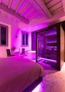 una camera viola con un grande letto e una vasca di F1RST Suite Apartment & SPA a Firenze