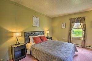 a bedroom with a bed with two lamps and a window at Spacious Home by Finger Lakes and Watkins Glen! in Burdett