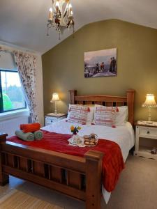 a bedroom with a large bed with a red blanket at Hillhead House in Ardara