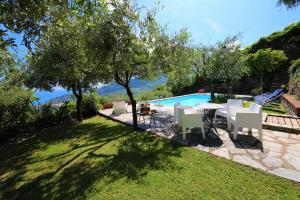 een achtertuin met een tafel en stoelen en een zwembad bij VILLA BELVEDERE by KlabHouse in Santa Margherita Ligure