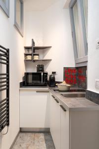 a kitchen with white cabinets and a microwave at F1RST Suite Apartment & SPA in Florence