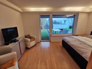 a bedroom with a bed and a tv and a large window at Haus mit Traumhaften Ausblick in Villach
